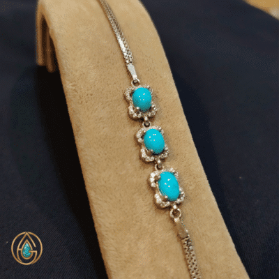 دستبند زنانه فیروزه نیشابور روی پایه مخملی – نمای روبه‌رو